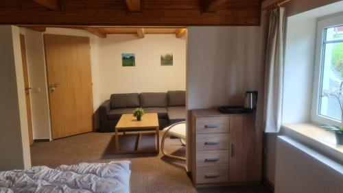 a living room with a couch and a table at Penzion V Kopci in Kořenov