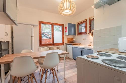 une cuisine avec une table et des chaises en bois dans l'établissement Apartment sleeping up to 10 in Morzine Centre, à Morzine