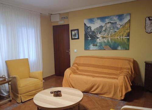 a bedroom with a bed and a chair and a table at Apartamento Barro Playa in Barro de Llanes