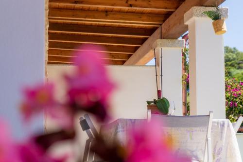 a table with pink flowers in the foreground at Villa Nova in Àrbatax