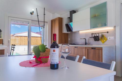 a bottle of wine sitting on a table with a wine glass at Villa Nova in Àrbatax