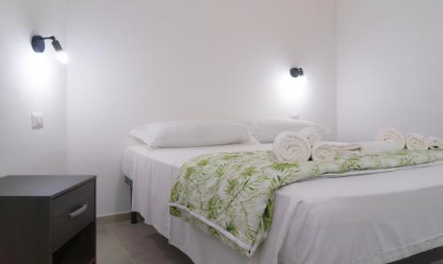 a bedroom with two beds with white sheets and towels at Villa Nova in Àrbatax
