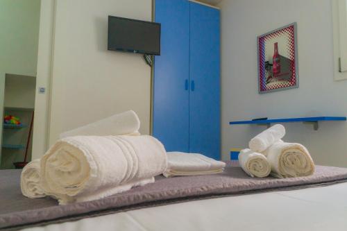 a pile of towels sitting on top of a bed at Villa Nova in Àrbatax