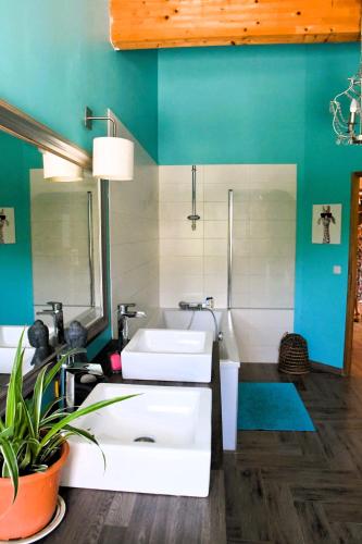 La salle de bains est pourvue de 2 lavabos blancs et d'un mur bleu. dans l'établissement Bergerie rénovée au cœur de la Provence, à Plan dʼAups