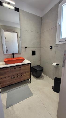 a bathroom with a black toilet and a sink at Vista del sole Kythnos in Kithnos