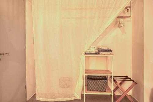 a room with a curtain and a shelf with a table at Santa Maria Hotel in Elia Beach