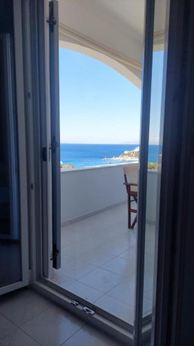 an open door to a balcony with a view of the ocean at Kini Bay in Kinion