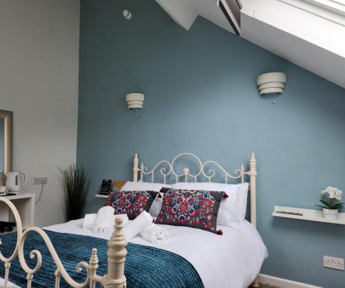 a bedroom with a white bed with blue walls at The Tuckers Arms in Dalwood