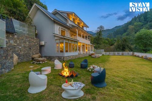 a house with a fire pit in the yard at StayVista at Riverside Symphony - Bonfire, BBQ, WiFi in Manāli