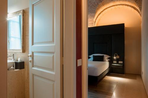 a bedroom with a bed and a bathroom with a mirror at Pavillon Suite in Peschiera del Garda