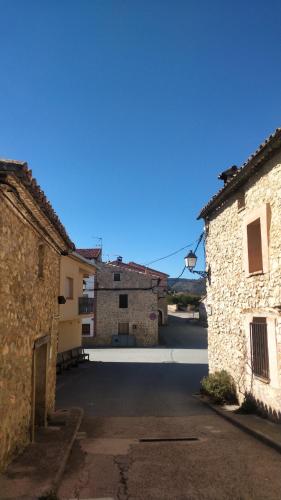 an empty parking lot between two stone buildings at Hotel el Castellar in Moscardón