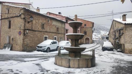 a fountain in the middle of a street covered in snow at Hotel el Castellar in Moscardón