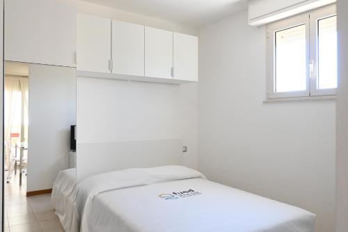 a white room with two beds and a window at SE170 - Senigallia, monolocale vista mare con aria condizionata in Senigallia