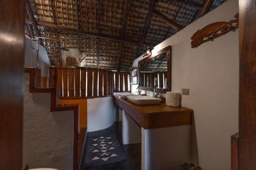 a bathroom with two sinks and a wooden counter at Villa Valiha Boutique Hotel in Madirokely