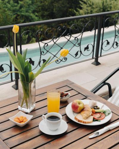 a table with plates of food and a glass of orange juice at Klinci Village Resort in Lustica