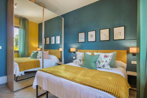 a bedroom with two beds and a mirror at I Levrieri Venezia in Torre del Lago Puccini