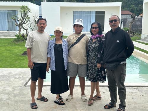 a group of people standing in front of a house at The Caldera Villas in Kubupenlokan