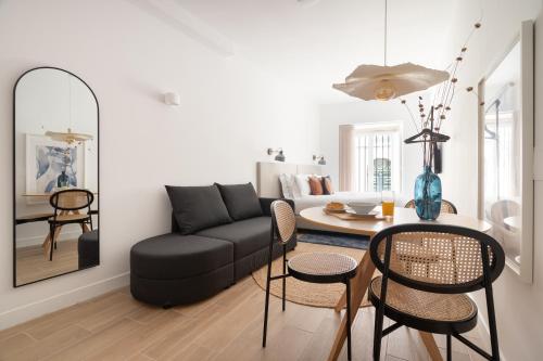 a living room with a black couch and a table at Lapa Diplomatic Suites & Flats by Feel Lisboa in Lisbon
