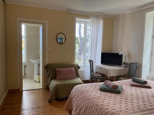 une chambre avec deux lits, un bureau et une télévision dans l'établissement VILLA LA VISTULE, à Dinard
