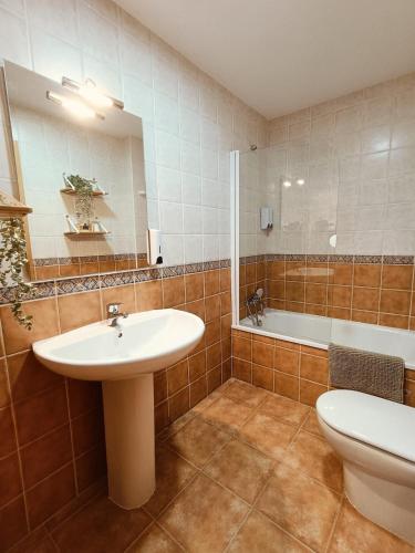a bathroom with a sink and a toilet and a tub at Mora Natura in Mora de Rubielos