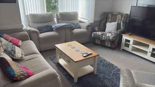 a living room with couches and a coffee table at 5 Bed Villa - Sleeps 10 - Pets - Garden - Parking in Skegness