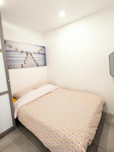 une chambre avec un lit et un tableau au mur dans l'établissement Pont du Lys - proche plages - piscine, à Juan-les-Pins