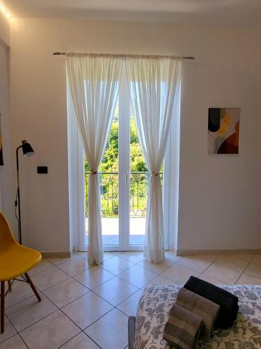 a bedroom with a bed and a large window at Casa Dolce Casa, 10 minuti dal mare di Sestri Levante POSTEGGIO E WIFI in Casarza Ligure