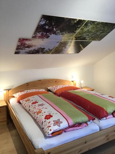 a bedroom with a bed with two quilts at Ferienwohnung Dorfblick (Herzog) in Lindberg