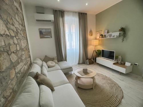 un soggiorno con un divano bianco e un muro di pietra di Storia Parentina Porec Center a Poreč (Parenzo)