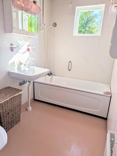 łazienka z wanną i umywalką w obiekcie Moonstone Meadow w mieście Ludvigsborg