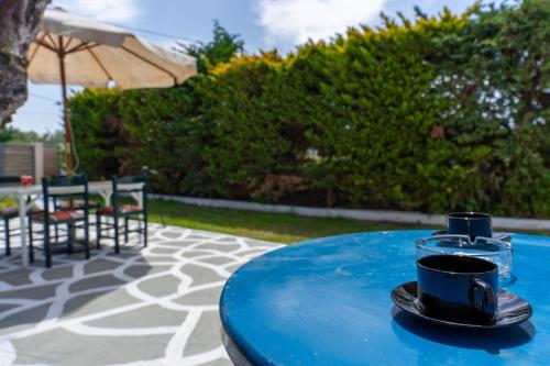 a blue table with a cup of coffee on it at Charming Loft with Lovely Yard in Gázion