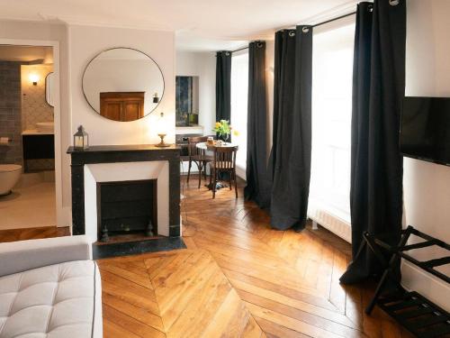 a living room with a fireplace and a mirror at Studio indépendant 27 m2 Jardin du Luxembourg in Paris