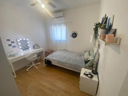 ein kleines Schlafzimmer mit einem Bett und einem Schreibtisch in der Unterkunft Big quiet Cottage in centre Raanana in Ra‘ananna