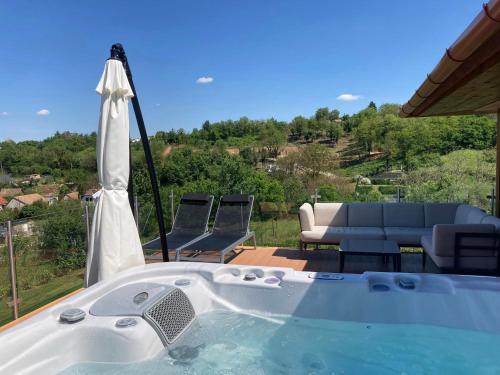 a jacuzzi tub with chairs and a couch at Lila akác vendégház in Keszü