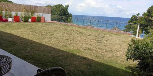a view of a lawn with the ocean in the background at The South Hideaway Oslob 