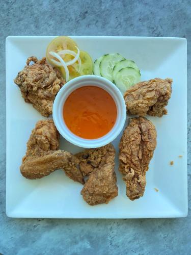 a plate of food with a dipping sauce and vegetables at The South Hideaway Oslob 