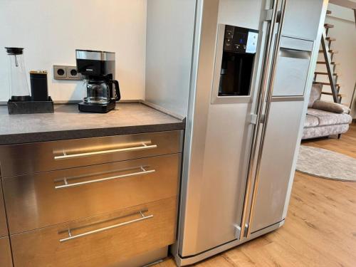 a kitchen with a stainless steel refrigerator in a room at Seeblick trifft Kampmannbrücke - Dein Lieblingsplatz in Essen