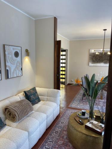 a living room with a white couch and a table at Villa Baltazar in Vila do Conde