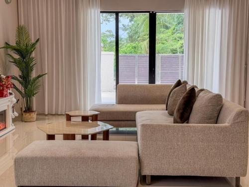 a living room with two couches and a table at Villa' Fiamma Taman Rambah Kukup Pontian in Kampong Teigong