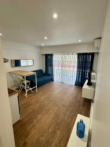 un salon avec un canapé bleu et une table dans l'établissement Joli Appartement 2 pieces Cannes, à Cannes