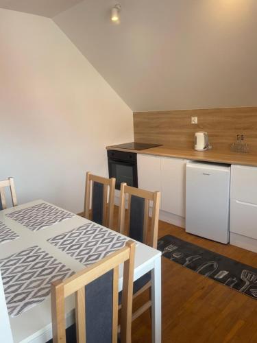 a kitchen with a table and chairs in a room at Aleda in Szczecin