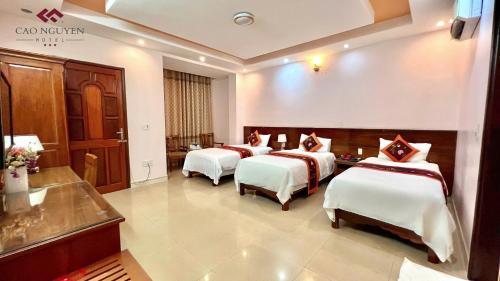 a hotel room with three beds in a room at Ha Giang Plateau Travel - Tours & Motorbikes Rental - Cao Nguyen Hotel in Ha Giang