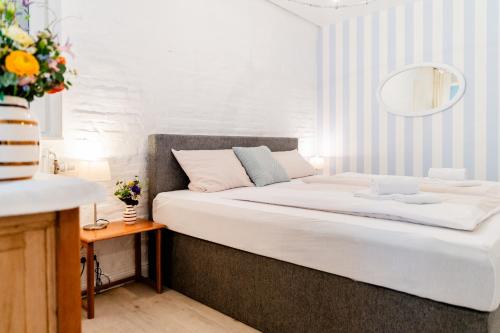 a small bedroom with a bed with white sheets at Altstadtapartment- Historischer Charme trifft modernen Komfort zentral & gemütlich mit Parkplatz! in Niederdorla