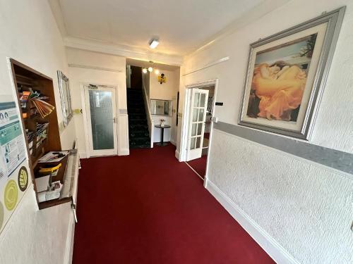 a hallway with a red carpet and a painting on the wall at Granby Hotel in Scarborough
