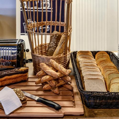 une table garnie de pain et d'une corbeille de gressins dans l'établissement ibis budget Auxerre Nord, à Auxerre