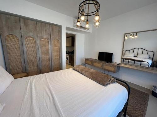 a bedroom with a large bed and a mirror at G Cribs hotel apartment in Hurghada