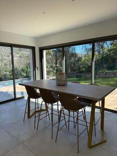 une salle à manger avec une table et des chaises en bois dans l'établissement Le Mazet, Dépendance au cœur de la garrigue, à Nîmes