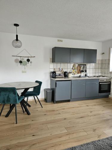 a kitchen with a table and a table and chairs at FeWo Stela in Bad Bellingen