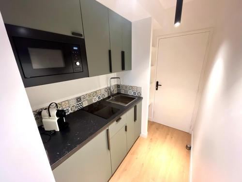 une cuisine avec un évier et un micro-ondes dans l'établissement Studio Neuf Clim 4p - Cannes, à Cannes