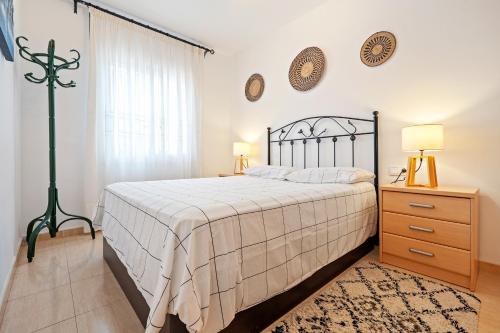 a bedroom with a bed and a dresser and a window at Hauzify I Casa Ribera in Cunit